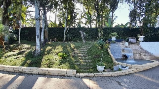 Área de lazer do Lar Peniel com jardim e bancos
